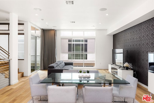 dining area with expansive windows and light hardwood / wood-style floors