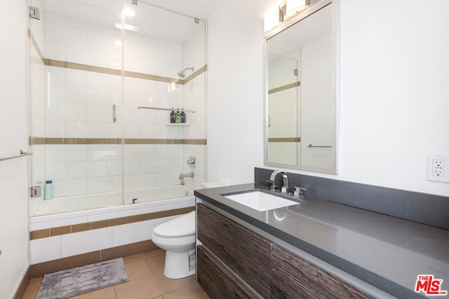 full bathroom featuring enclosed tub / shower combo, vanity, toilet, and tile patterned floors