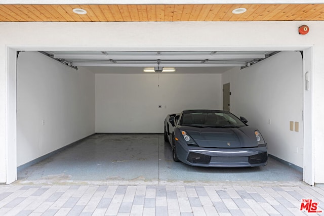 garage with wood ceiling, a garage door opener, and electric panel