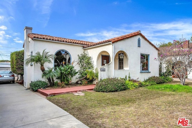 mediterranean / spanish house featuring a front yard