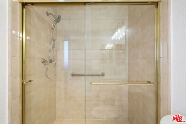 bathroom featuring a shower with shower door