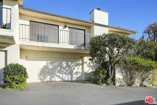 exterior space featuring a garage and a balcony