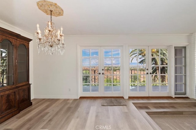 entryway featuring ornamental molding, light hardwood / wood-style floors, and french doors