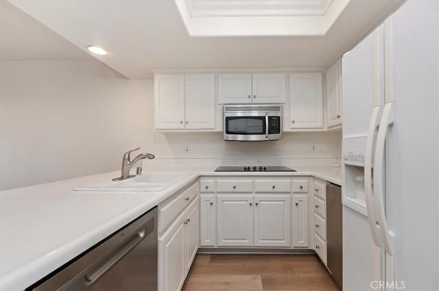 kitchen featuring white cabinetry, appliances with stainless steel finishes, light hardwood / wood-style floors, and sink