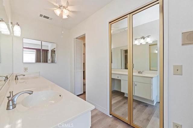 bathroom with wood-type flooring, vanity, and ceiling fan