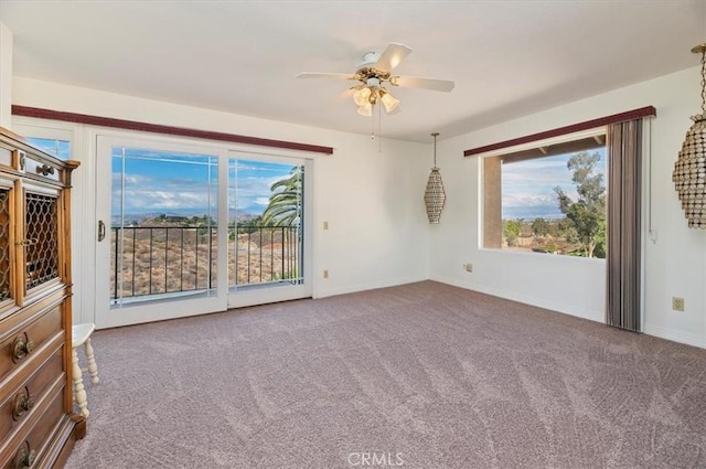 carpeted empty room with plenty of natural light and ceiling fan