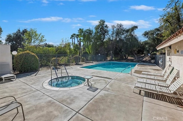 view of swimming pool with a hot tub and a patio