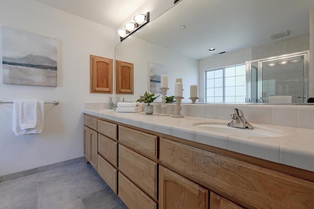 bathroom featuring tile patterned flooring, vanity, and a shower with shower door