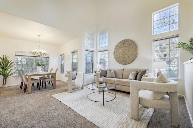 living room with a high ceiling, carpet floors, and a notable chandelier