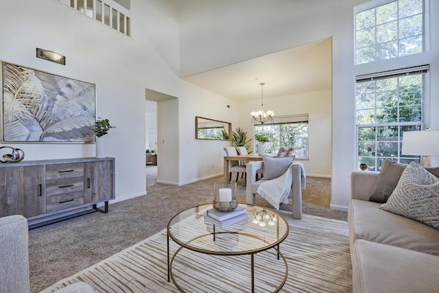 living room with light colored carpet, a towering ceiling, and a notable chandelier