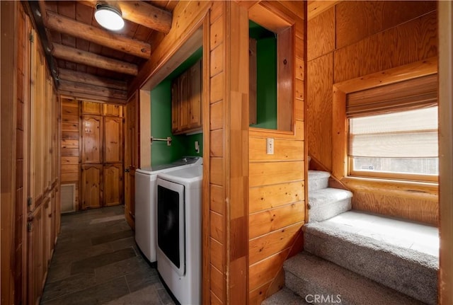 laundry room with washing machine and dryer, wooden ceiling, wooden walls, visible vents, and cabinet space