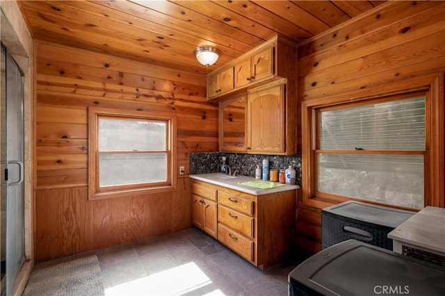 kitchen with light countertops, wood ceiling, backsplash, wooden walls, and brown cabinetry