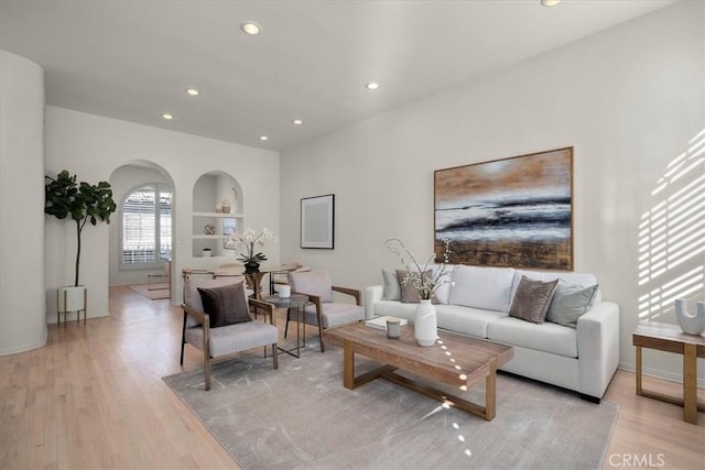 living room featuring built in features and light hardwood / wood-style floors