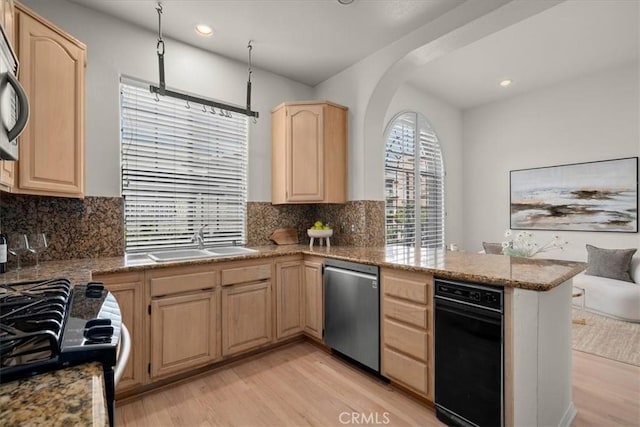 kitchen with backsplash, appliances with stainless steel finishes, kitchen peninsula, and light brown cabinets