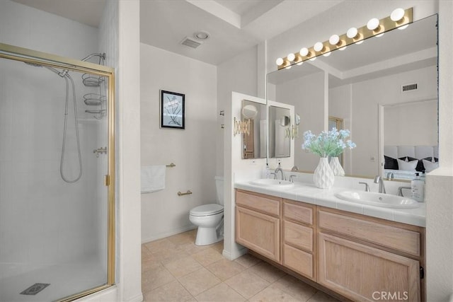 bathroom featuring a shower with door, vanity, tile patterned floors, and toilet