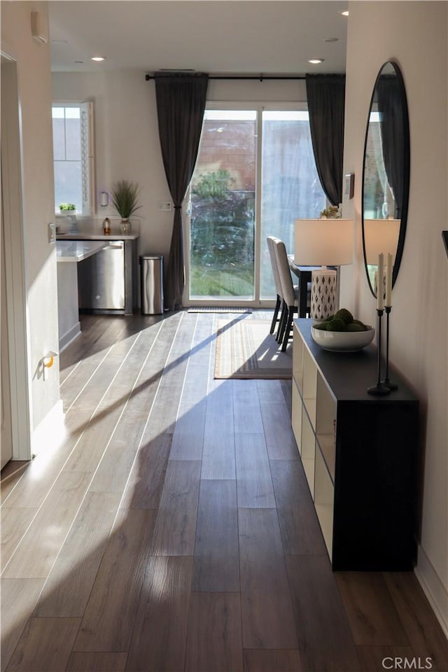 hallway with a healthy amount of sunlight and light wood-type flooring