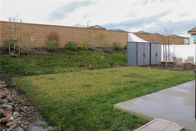 view of yard featuring a shed and a patio area