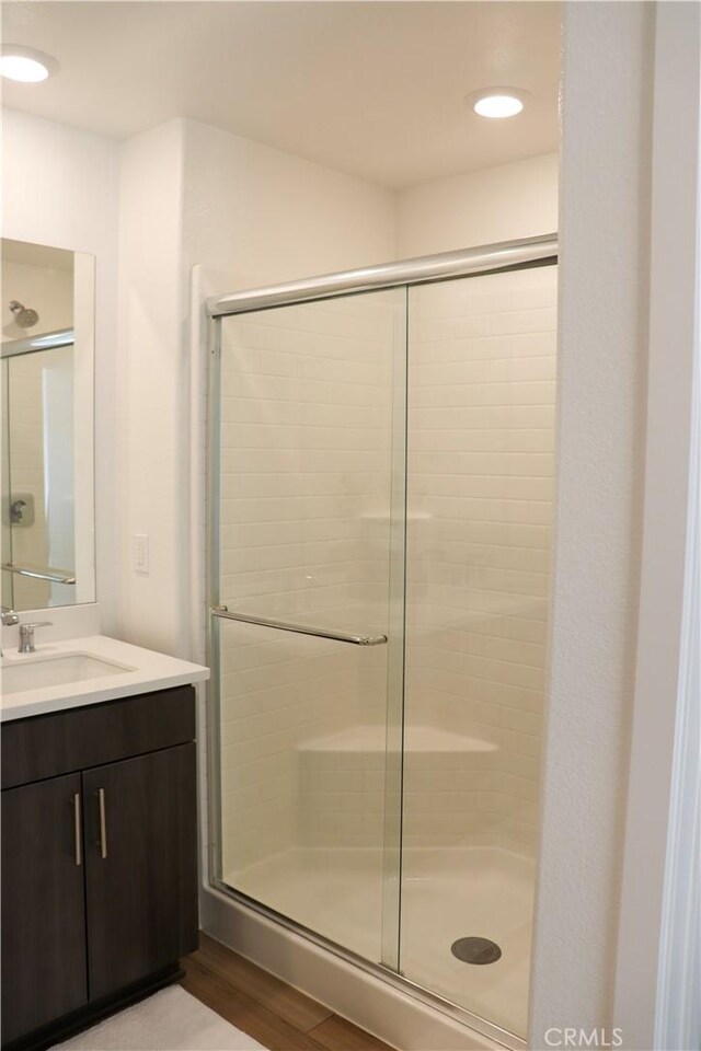 bathroom with vanity, hardwood / wood-style floors, and walk in shower