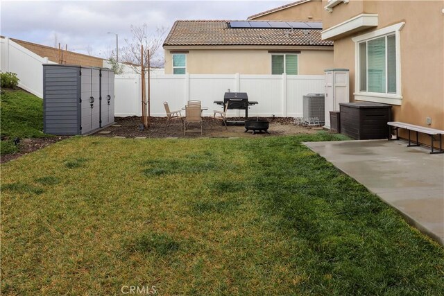 view of yard featuring central AC unit, a patio area, and a storage unit