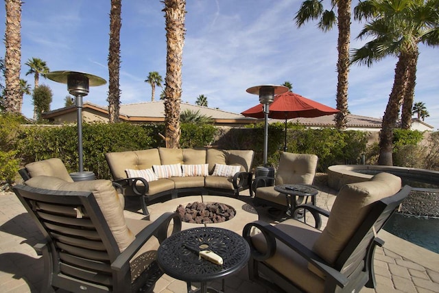 view of patio with an outdoor living space with a fire pit