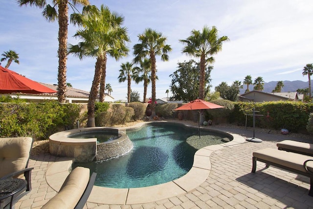 view of swimming pool featuring a mountain view, a patio, and an in ground hot tub