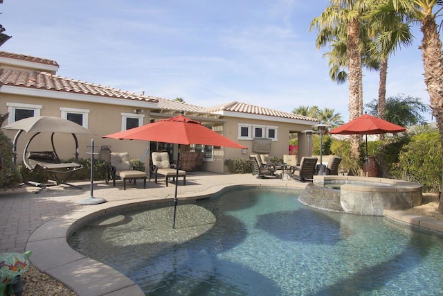 view of pool with a patio and an in ground hot tub