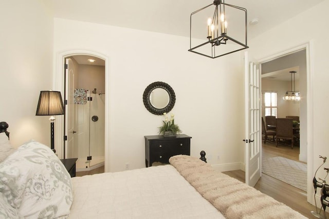 bedroom featuring an inviting chandelier and light hardwood / wood-style floors