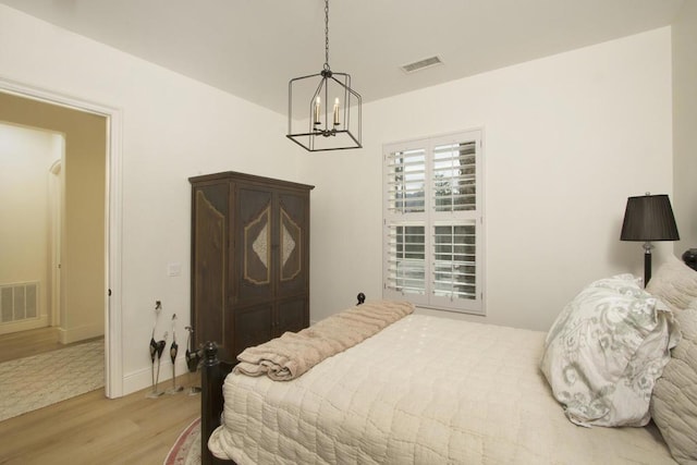 bedroom with a chandelier and light hardwood / wood-style flooring