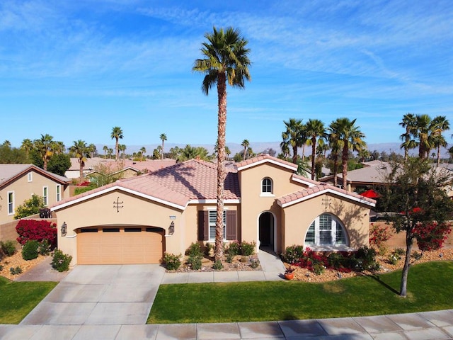 mediterranean / spanish house with a garage and a front yard