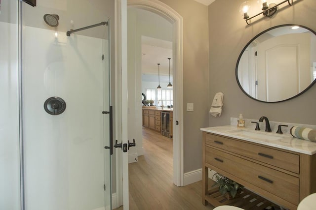 bathroom with wine cooler, vanity, wood-type flooring, and walk in shower