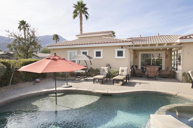 view of swimming pool featuring a mountain view, a patio area, and an outdoor hangout area