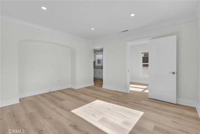 empty room featuring crown molding and light hardwood / wood-style flooring