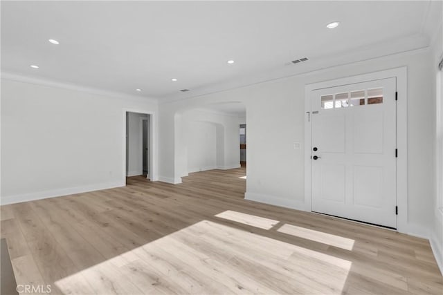 foyer featuring crown molding and light hardwood / wood-style floors