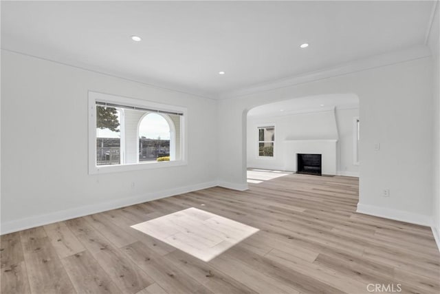 unfurnished living room with crown molding and light wood-type flooring