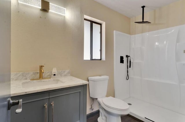 bathroom featuring vanity, toilet, and walk in shower