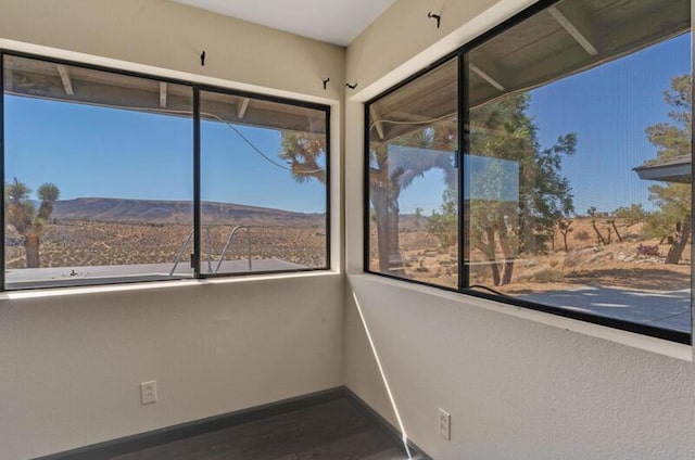 unfurnished sunroom featuring a mountain view