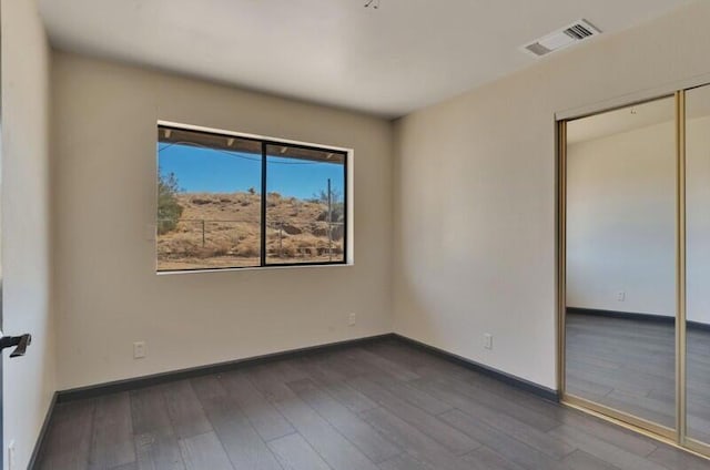 spare room with dark wood-type flooring