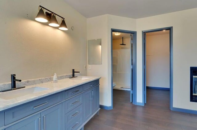 bathroom featuring vanity, hardwood / wood-style floors, toilet, and walk in shower