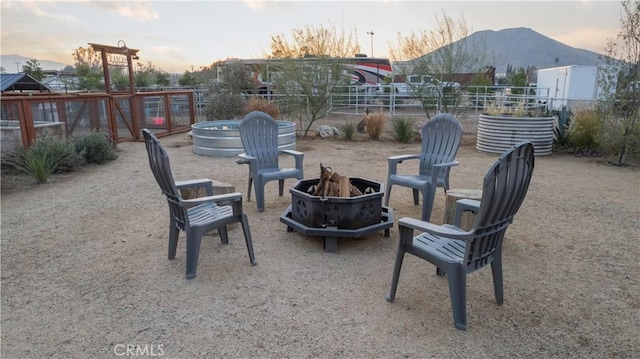 patio terrace at dusk with an outdoor fire pit and a mountain view