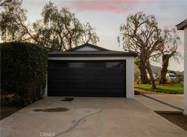 view of garage at dusk