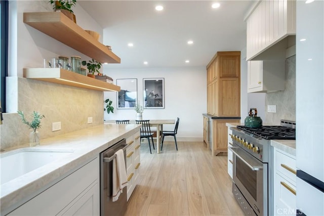 kitchen featuring backsplash, light hardwood / wood-style flooring, stainless steel appliances, and white cabinets