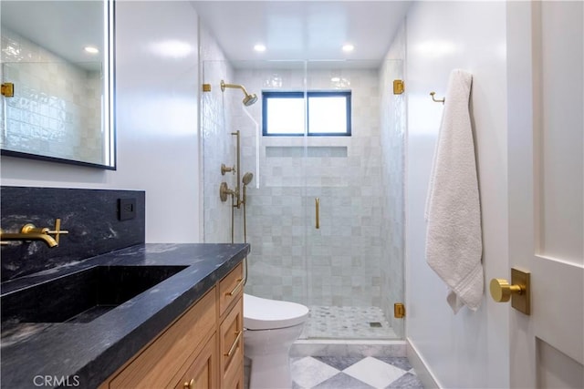 bathroom featuring vanity, an enclosed shower, and toilet