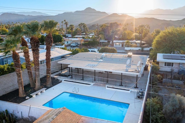 view of swimming pool with a patio and a mountain view