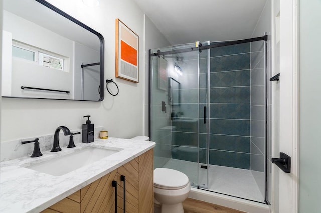 bathroom featuring walk in shower, vanity, toilet, and hardwood / wood-style floors