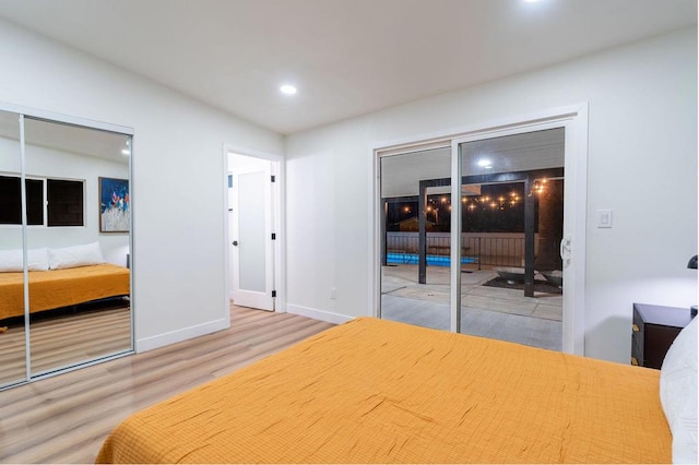 bedroom with a fireplace and light hardwood / wood-style floors