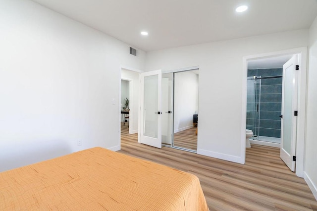 unfurnished bedroom with connected bathroom, light hardwood / wood-style flooring, and a closet