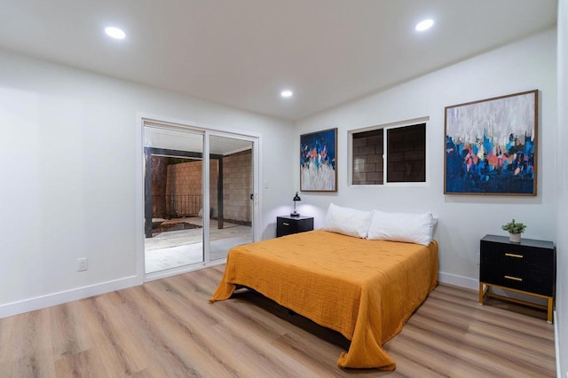 bedroom with access to outside and wood-type flooring