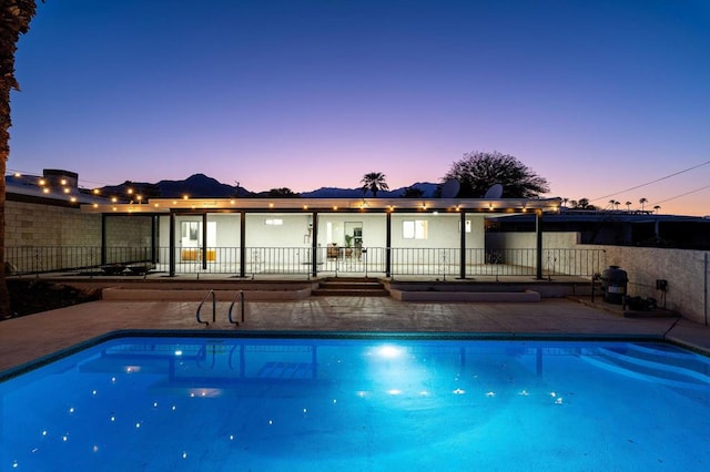 pool at dusk featuring a patio area