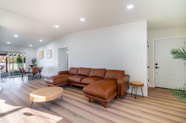 living room featuring lofted ceiling and light hardwood / wood-style flooring