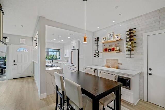 dining area with sink and light hardwood / wood-style floors